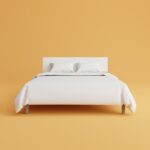 a bed with a white cover and pillows on top of it