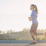 woman jogging near wire fence