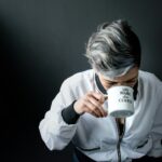 woman holding mug in drinking gesture